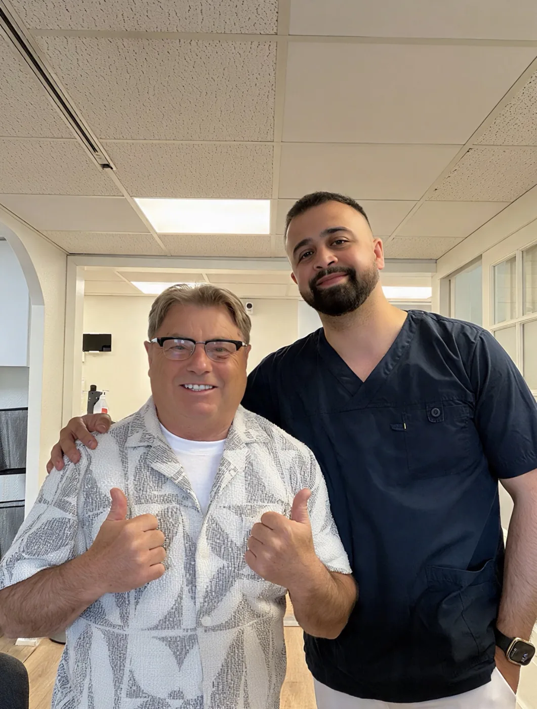 Tandläkare Omid Khatgar tillsammans med en nöjd patient på Kinna Tandhälsa