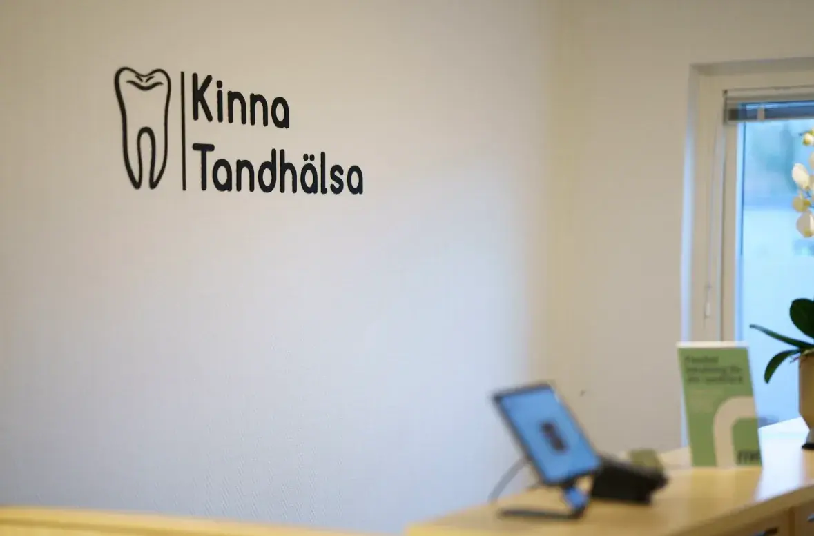 Receptionen på Kinna Tandhälsa med klinikens logotyp på väggen